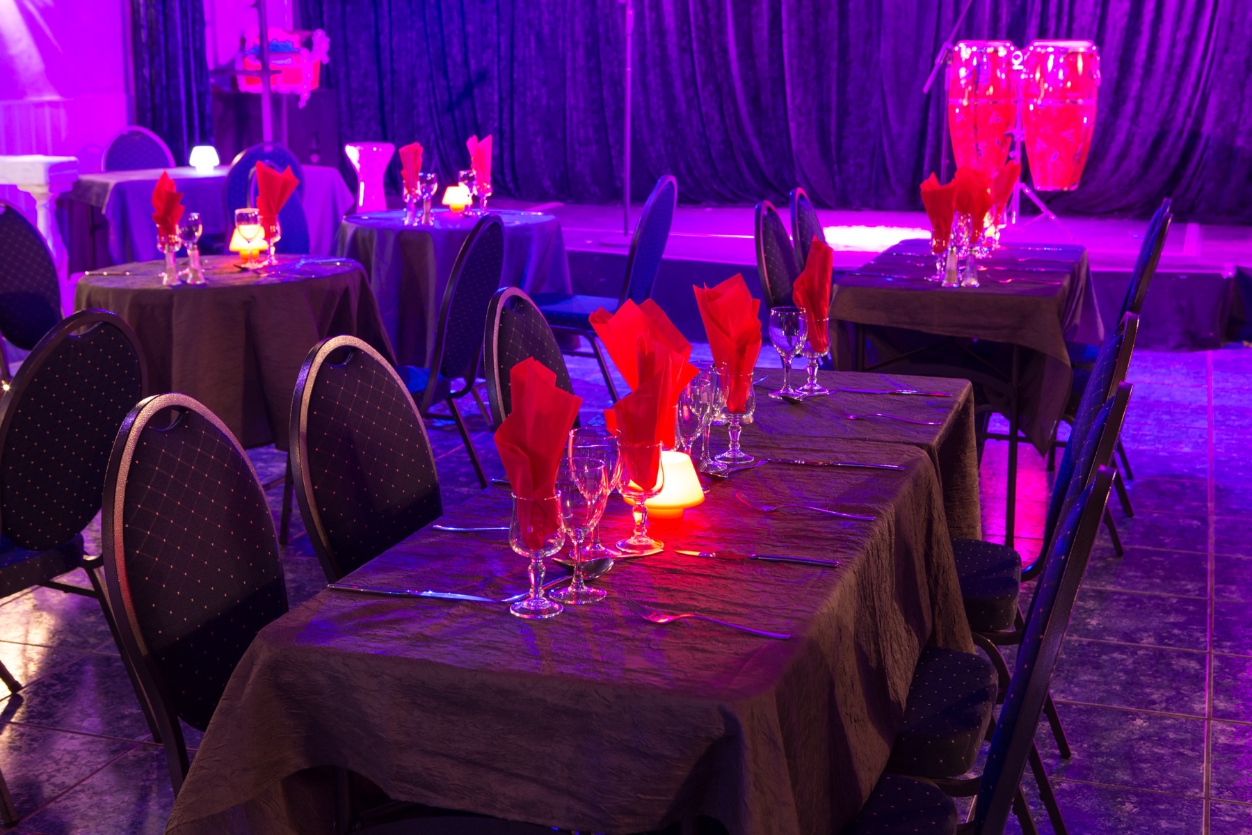 Les tables dressées face à la scène du cabaret Le Moulin Bleu